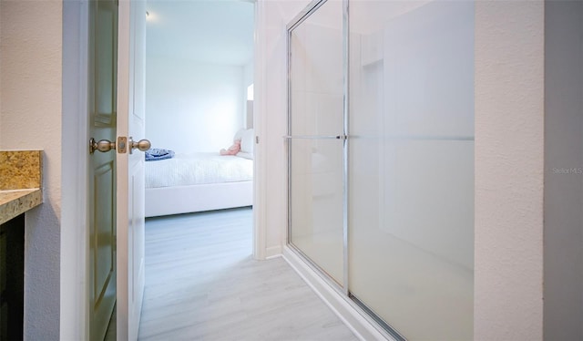 bathroom with vanity, hardwood / wood-style flooring, and a shower with shower door