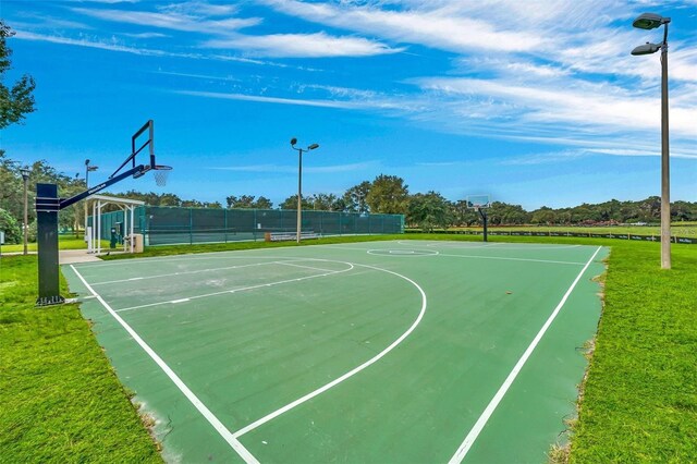 view of sport court with a lawn