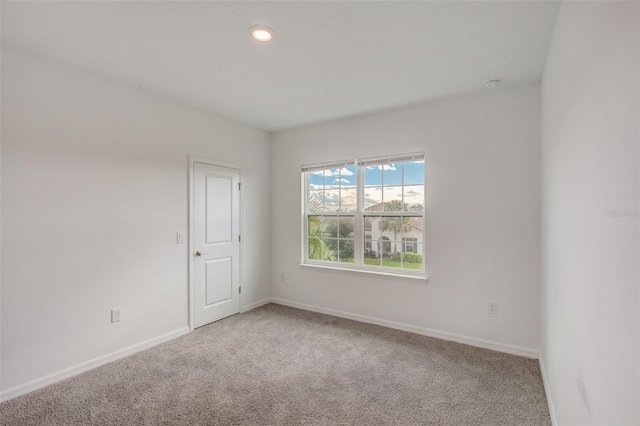 spare room featuring light colored carpet