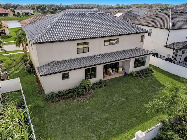 back of property featuring a patio area and a yard