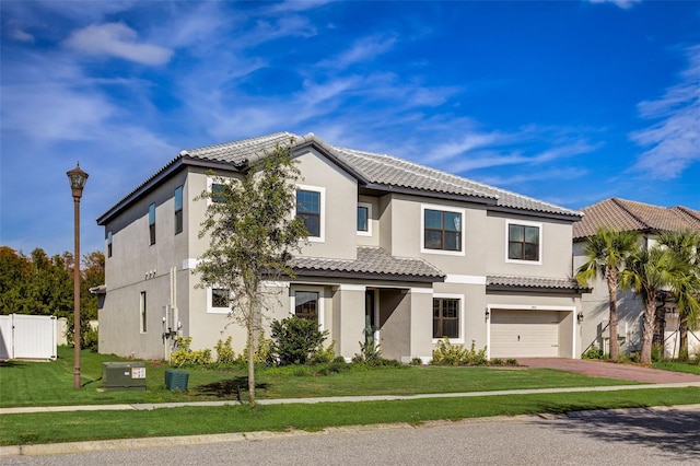 mediterranean / spanish-style house with central air condition unit, a garage, and a front lawn