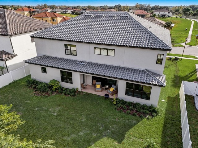 rear view of house featuring a patio area and a yard