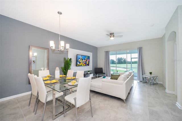 tiled dining space featuring ceiling fan with notable chandelier