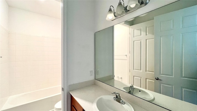 bathroom with toilet, vanity, and an inviting chandelier