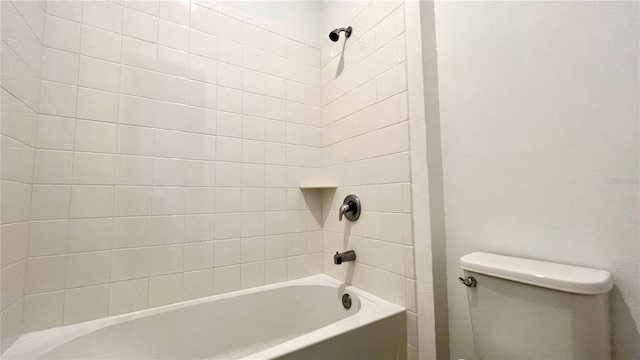 bathroom featuring toilet and tiled shower / bath combo