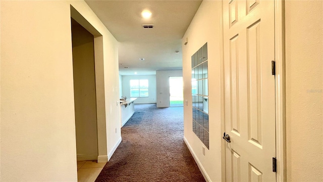 hall featuring carpet flooring