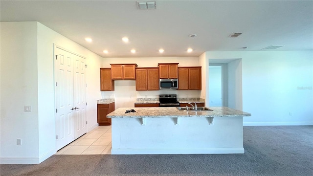 kitchen with light colored carpet, a center island with sink, a breakfast bar, and electric range oven