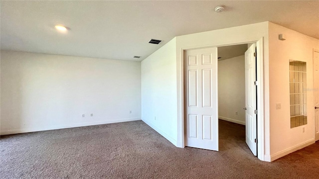 spare room with dark colored carpet