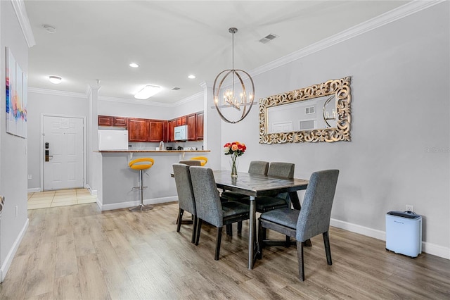 dining area featuring a chandelier, light hardwood / wood-style flooring, and crown molding