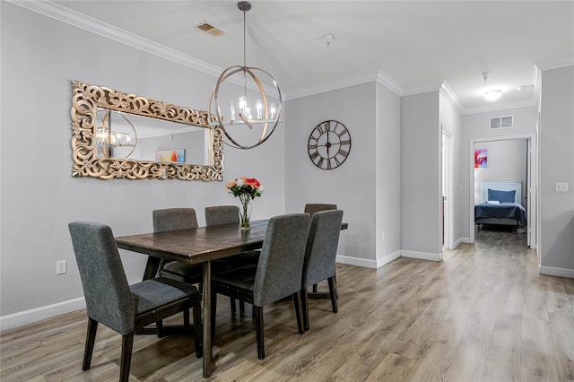 dining room featuring a chandelier, hardwood / wood-style flooring, and crown molding