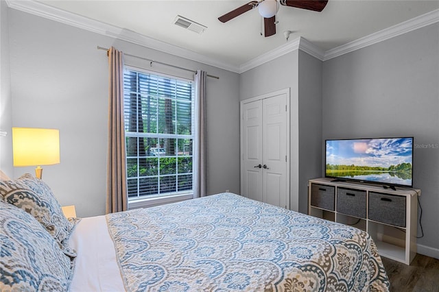 bedroom featuring a closet, hardwood / wood-style flooring, ceiling fan, and crown molding