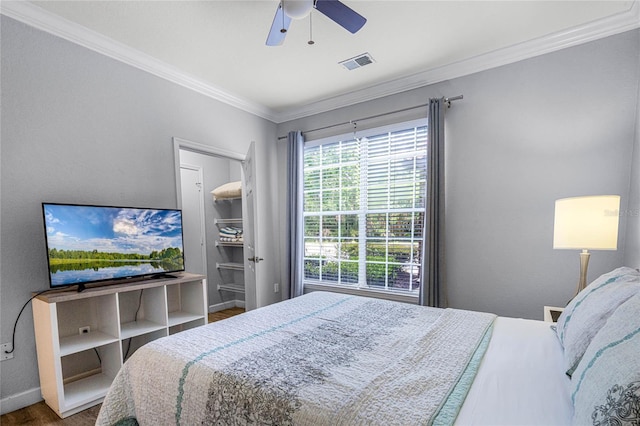 bedroom with hardwood / wood-style floors, ceiling fan, and crown molding