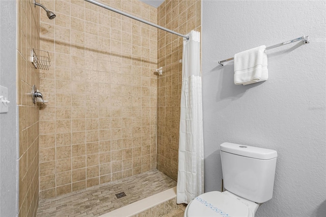 bathroom with a shower with shower curtain and toilet