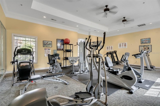 gym featuring ceiling fan, a raised ceiling, and ornamental molding