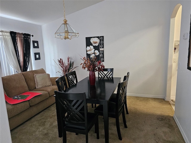 dining area with an inviting chandelier and carpet flooring