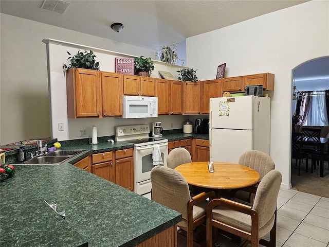 kitchen with light tile patterned floors, sink, and white appliances