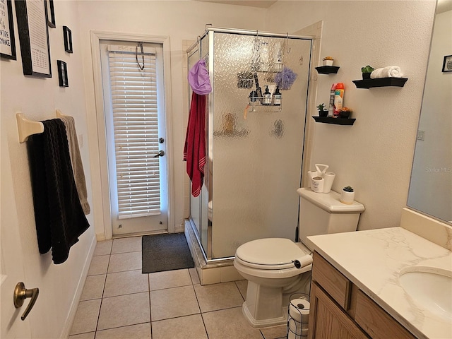 bathroom with toilet, tile patterned floors, vanity, and an enclosed shower