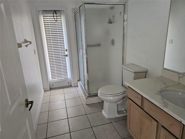 bathroom with a shower with shower door, tile patterned floors, vanity, and toilet