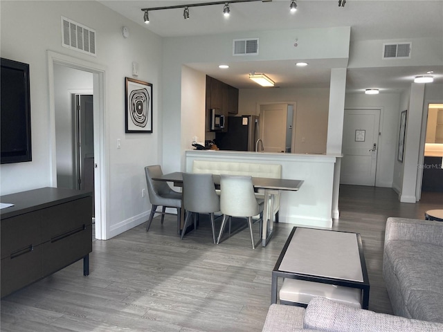 dining room with rail lighting and light hardwood / wood-style floors