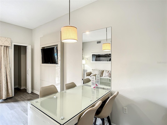 dining space featuring visible vents, baseboards, and wood finished floors