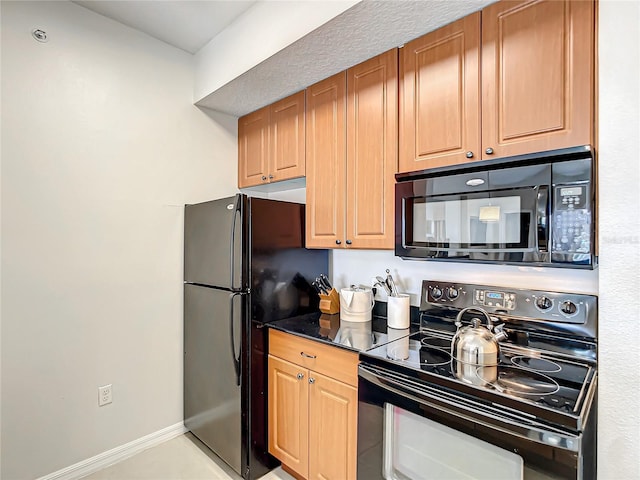 kitchen with dark countertops, baseboards, and black appliances