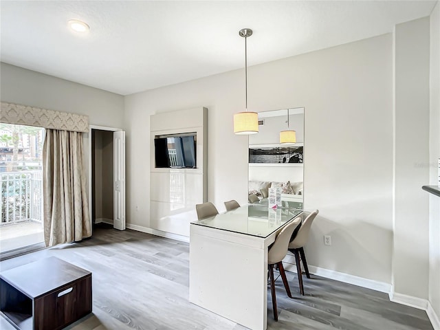 dining area with baseboards and wood finished floors