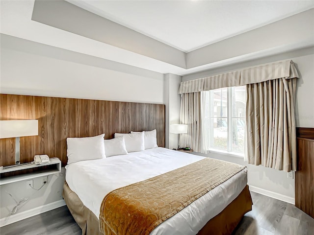 bedroom with dark wood-style flooring and baseboards