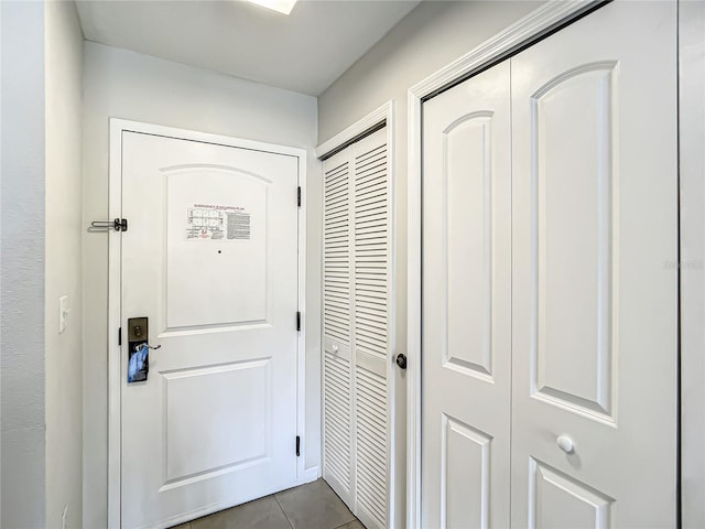 doorway with dark tile patterned floors