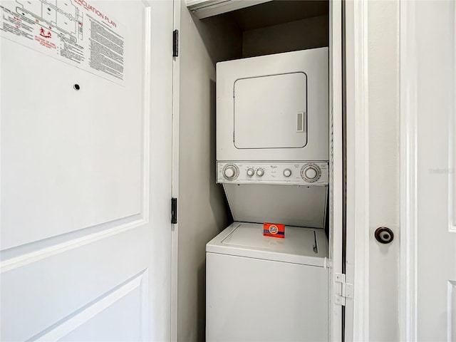 washroom featuring stacked washer and dryer and laundry area