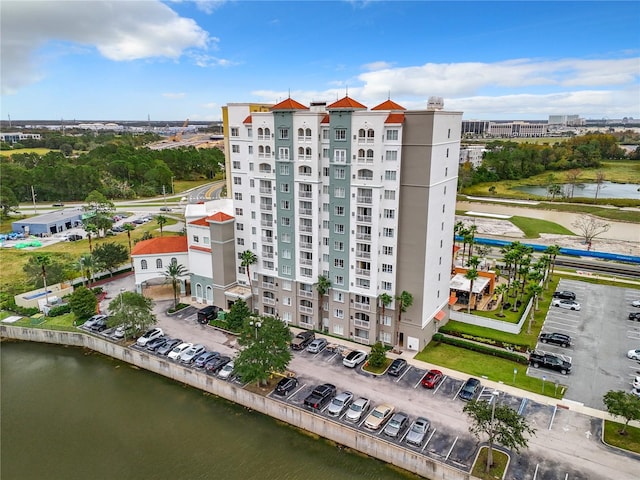 view of property with uncovered parking and a water view