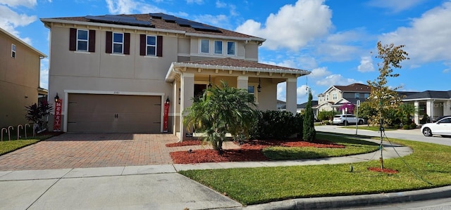 view of front of home with solar panels, a residential view, stucco siding, decorative driveway, and a garage