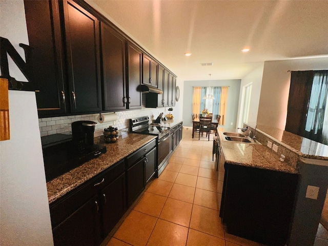 kitchen with light tile patterned floors, a sink, decorative backsplash, electric stove, and under cabinet range hood