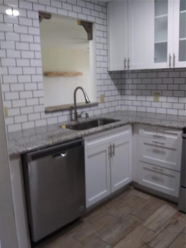 kitchen featuring sink, white cabinetry, backsplash, dishwasher, and light stone counters