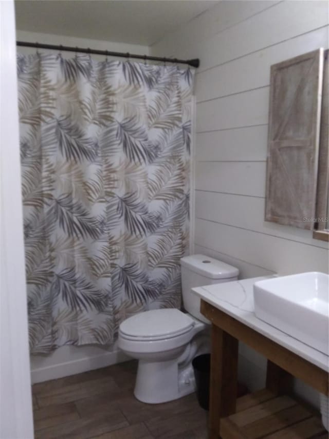 bathroom with toilet and hardwood / wood-style floors