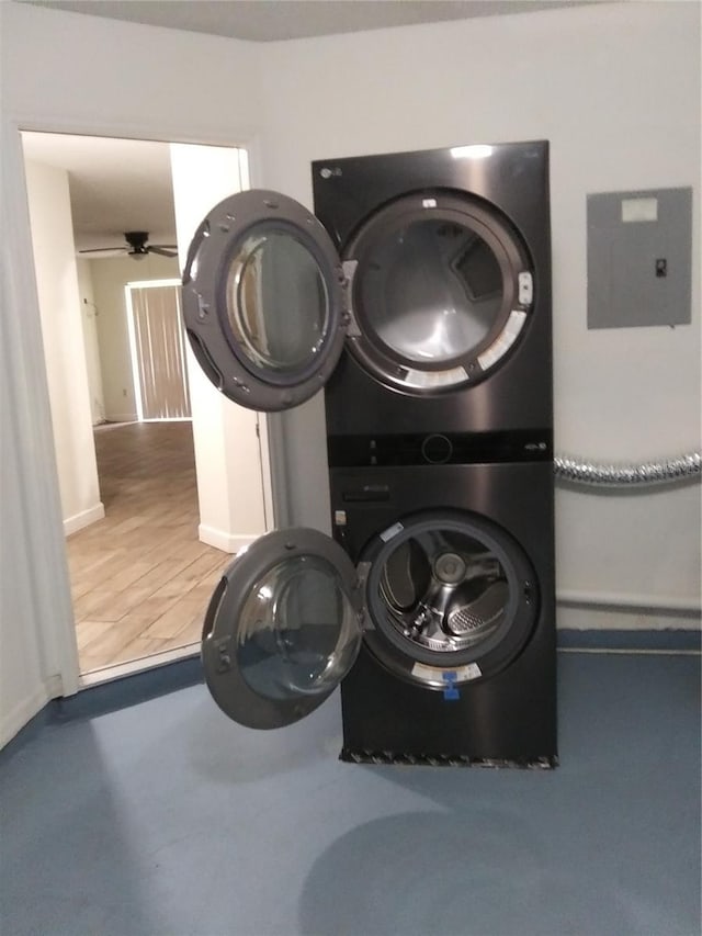 laundry area with stacked washer and clothes dryer, dark hardwood / wood-style floors, and ceiling fan