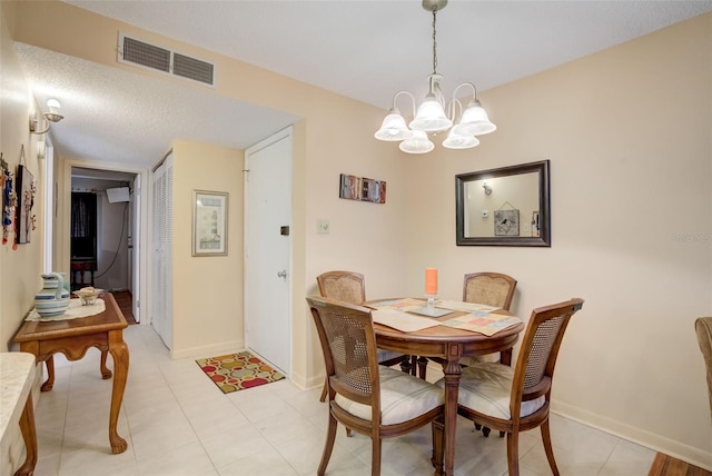 dining room with a textured ceiling, a notable chandelier, and light tile patterned flooring