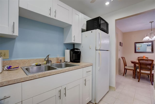 kitchen with sink, light tile patterned floors, decorative light fixtures, a notable chandelier, and white cabinets