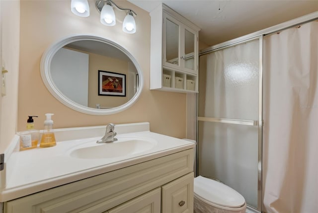 bathroom with vanity, toilet, and a shower