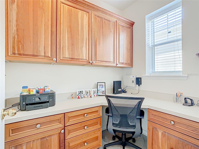 home office featuring tile patterned floors and built in desk