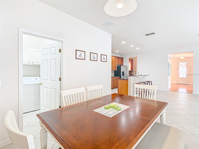 tiled dining room featuring washer / dryer