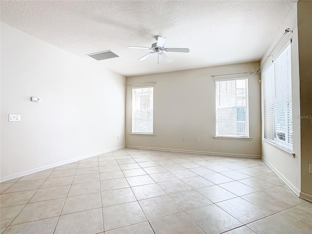 tiled spare room featuring ceiling fan and a textured ceiling