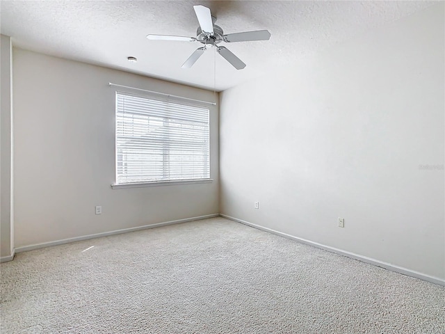 carpeted spare room featuring a textured ceiling and ceiling fan