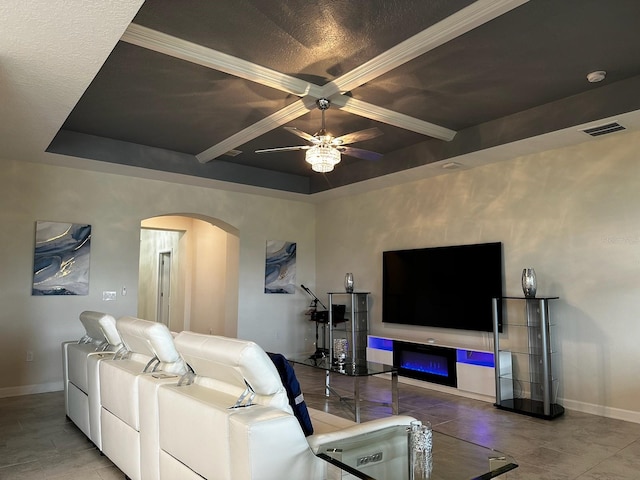 living room featuring ceiling fan and a tray ceiling