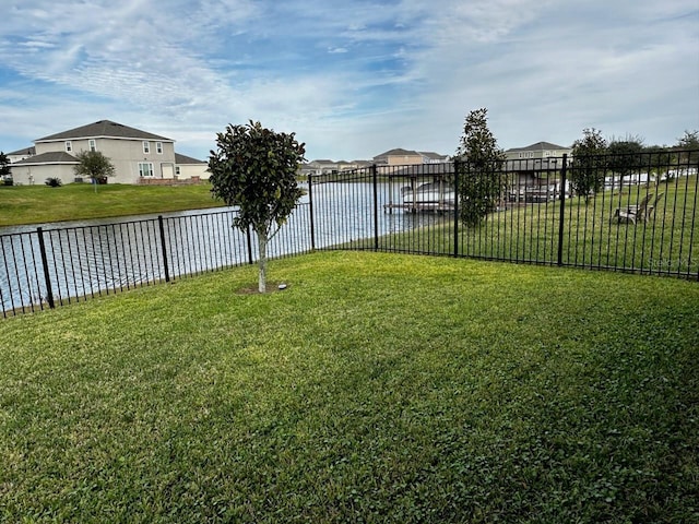 view of yard featuring a water view and fence