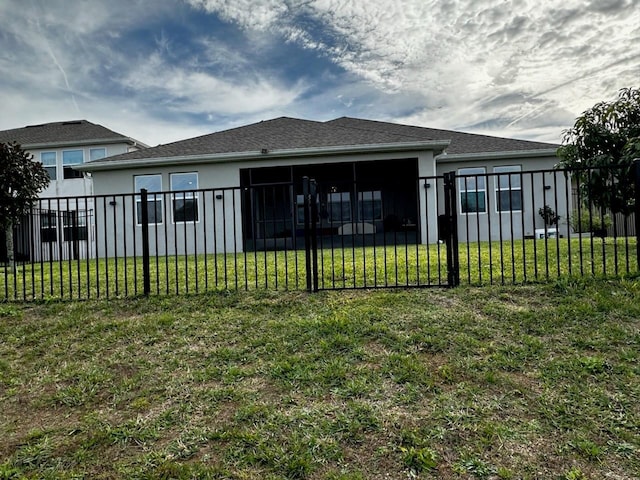 back of house with a yard, fence, a sunroom, and stucco siding