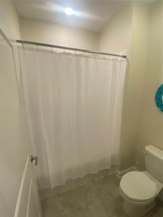 bathroom with toilet and shower / tub combo with curtain