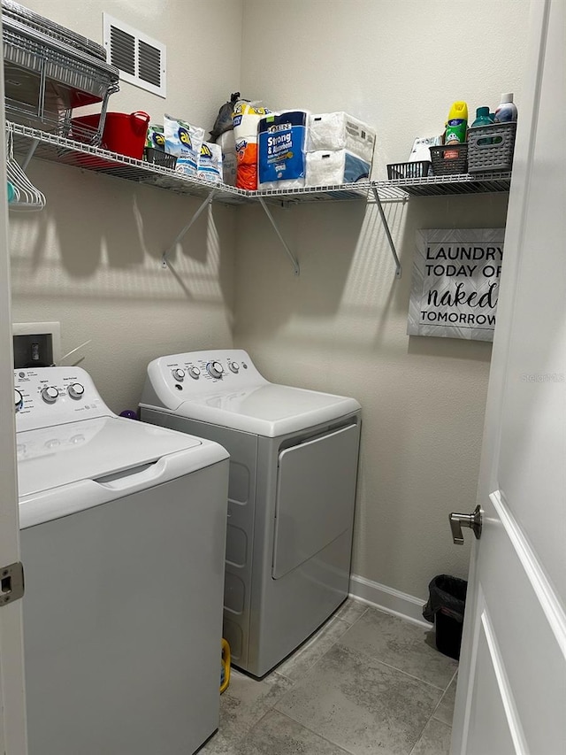 washroom with washer and clothes dryer, visible vents, laundry area, and baseboards