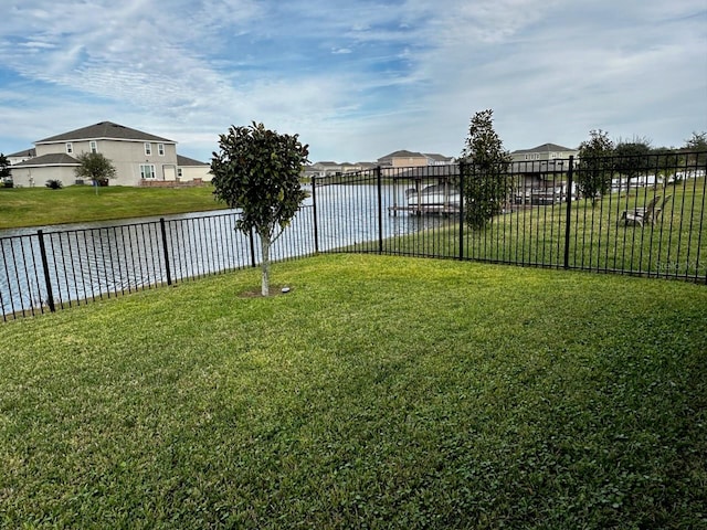 view of yard with a water view and fence