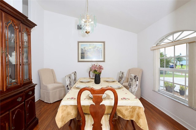 dining room with dark hardwood / wood-style floors, a chandelier, and vaulted ceiling