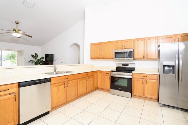 kitchen with light tile patterned floors, high vaulted ceiling, appliances with stainless steel finishes, and sink